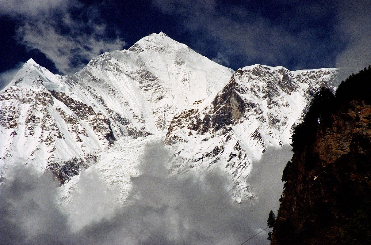 304 Dhaulagiri From Just Before Khobang A little farther on we saw the upper slopes of Dhaulagiri, streaked with blue ice. The south-east ridge running down towards us, of which we had some hope, extended endlessly, as sharp as a blade of a knife and bristling with ice pinnacles and snow cornices - absolutely impregnable